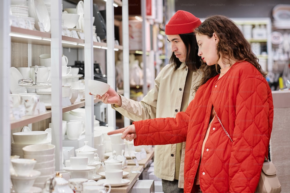 a couple of people that are looking at a shelf