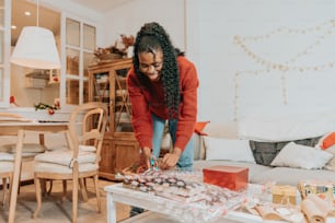 a woman standing over a table with a bunch of presents on it