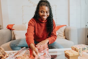 a woman sitting on a couch with presents in front of her