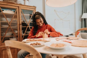 a woman sitting at a table with plates of food