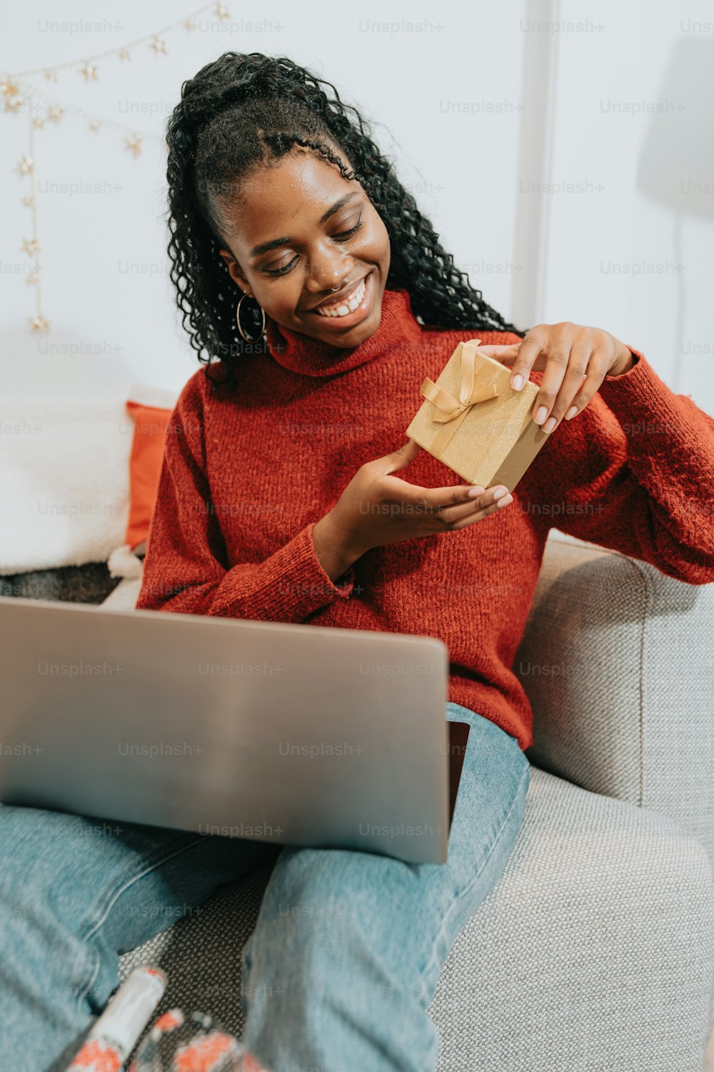 a woman sitting on a couch holding a brown paper bag