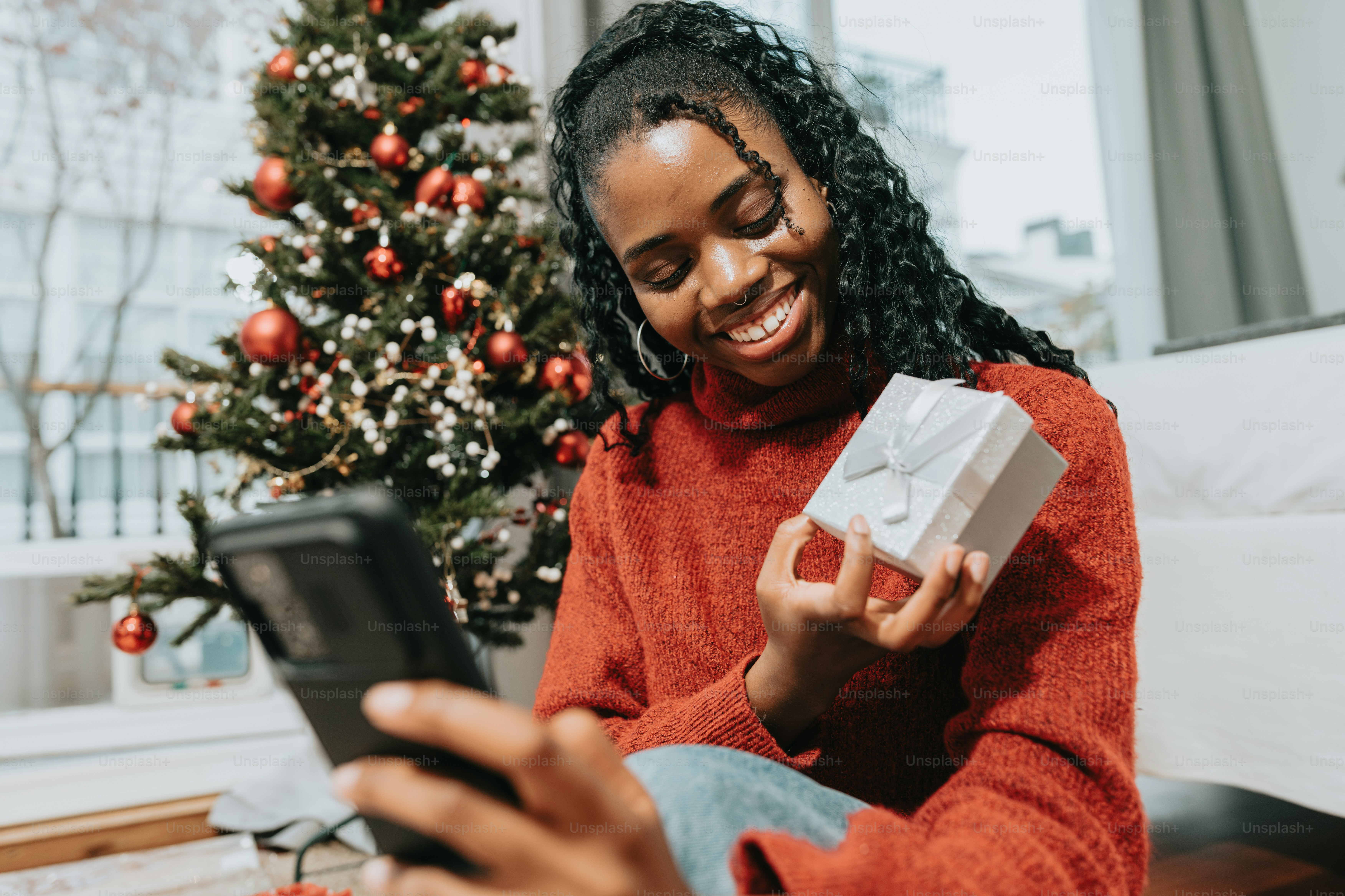 a woman in a red sweater is holding a present