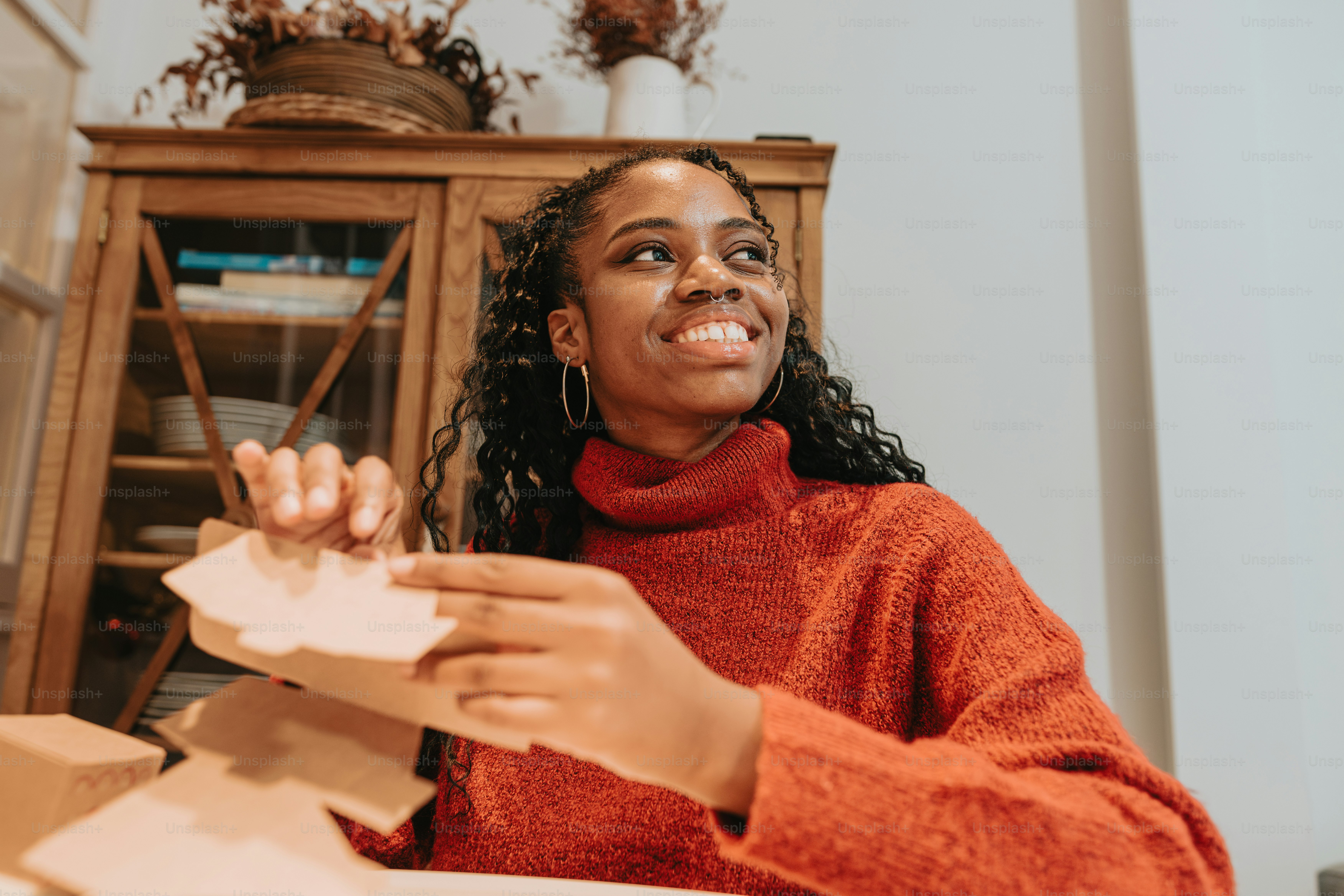 a woman sitting at a table holding a piece of paper
