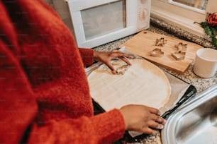 a woman is making cookies on a cutting board