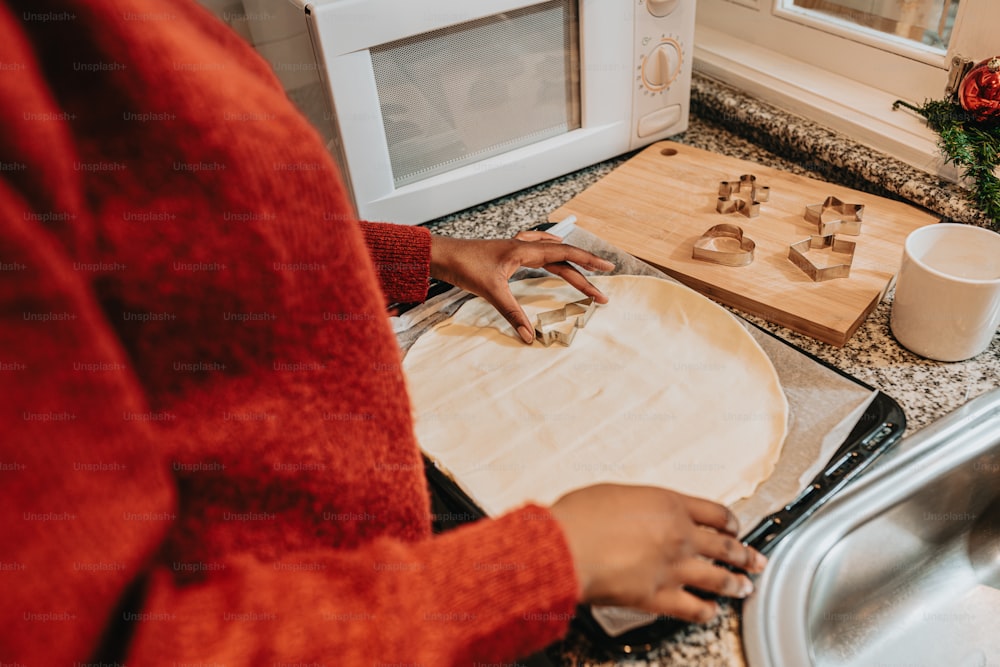 a woman is making cookies on a cutting board