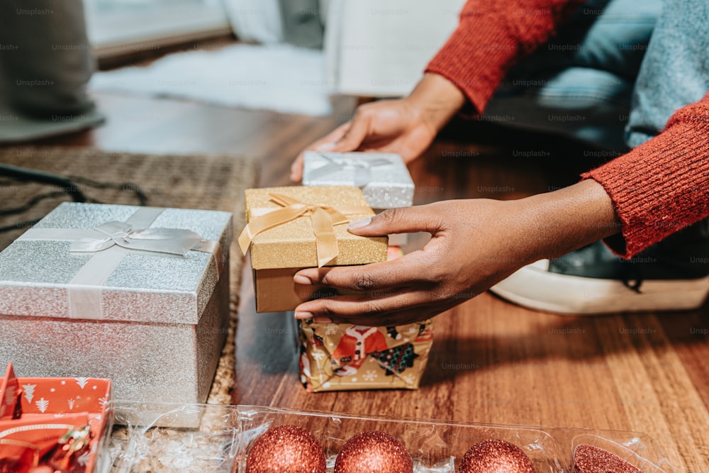 a person holding a wrapped gift box with a bow