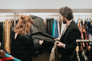 a man and a woman looking at clothes in a store