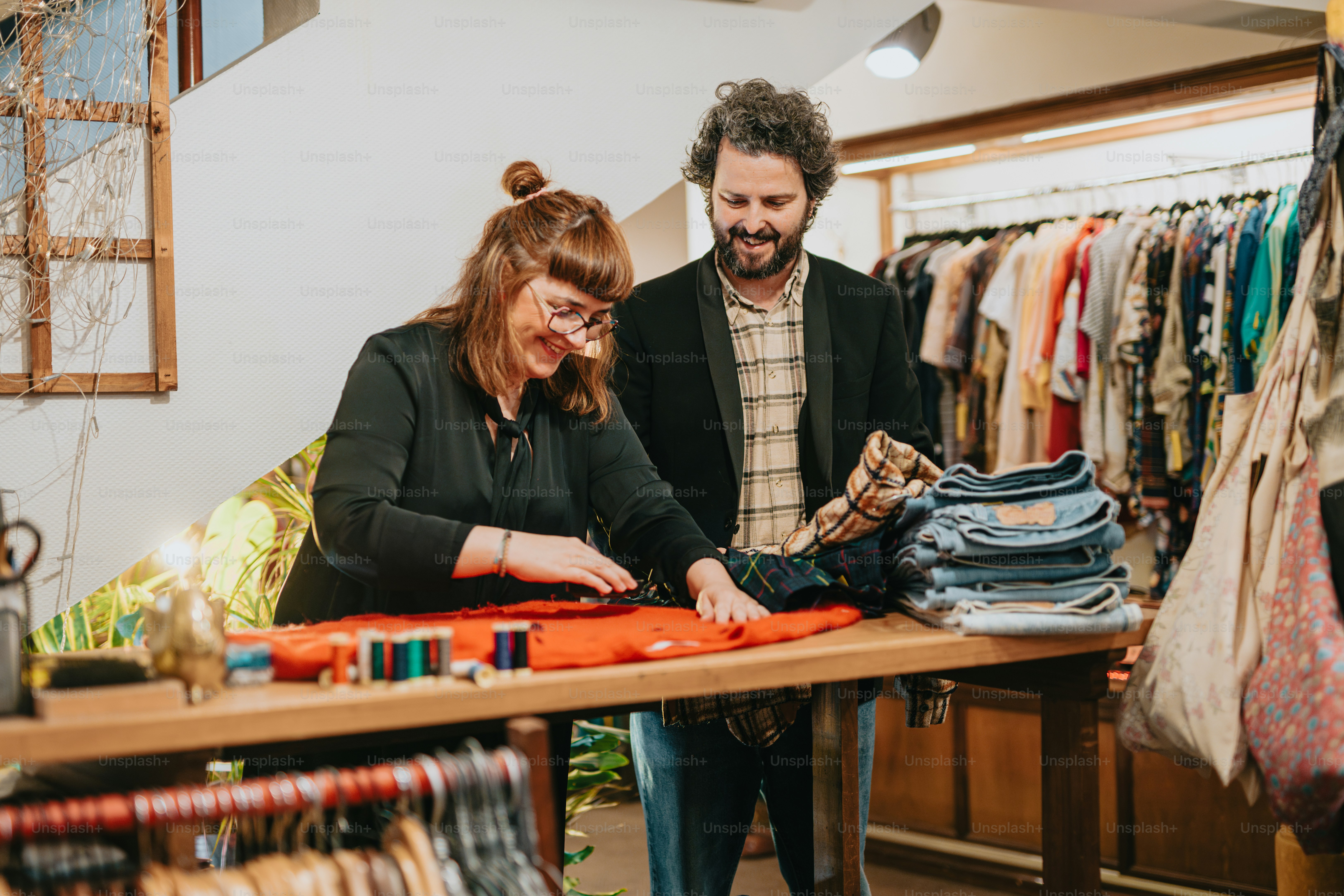 un hombre y una mujer mirando la ropa sobre una mesa