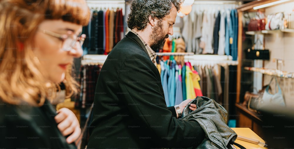 a man and woman looking at clothing in a store