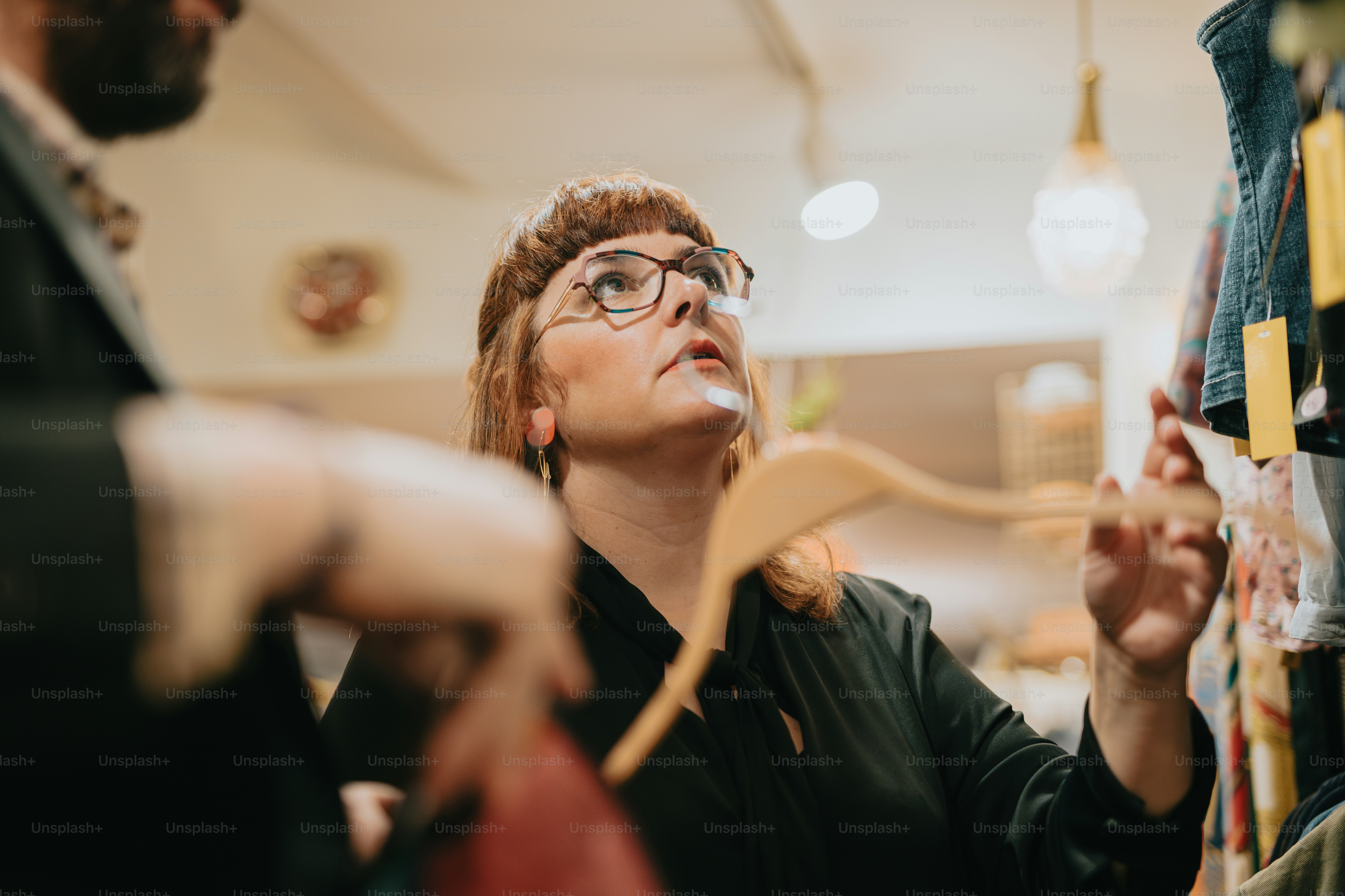 a woman with glasses is looking up at something