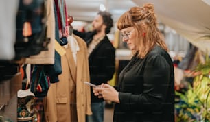 Una mujer mirando un teléfono celular en una tienda