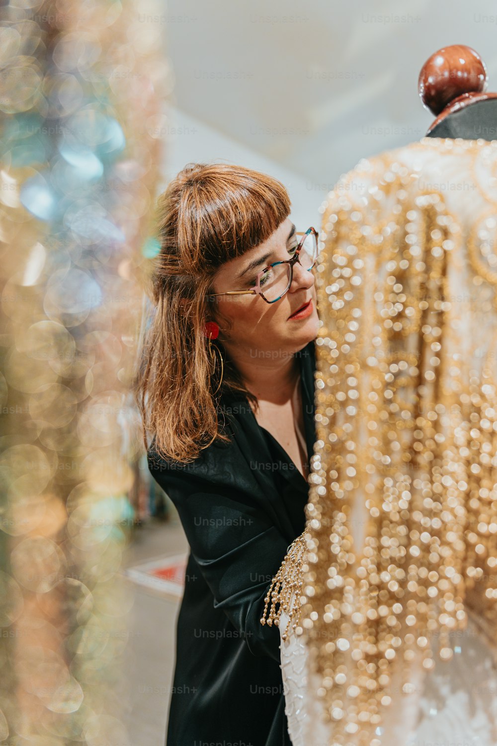 a woman looking at a dress on a mannequin