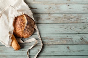 una hogaza de pan en una bolsa sobre una mesa de madera