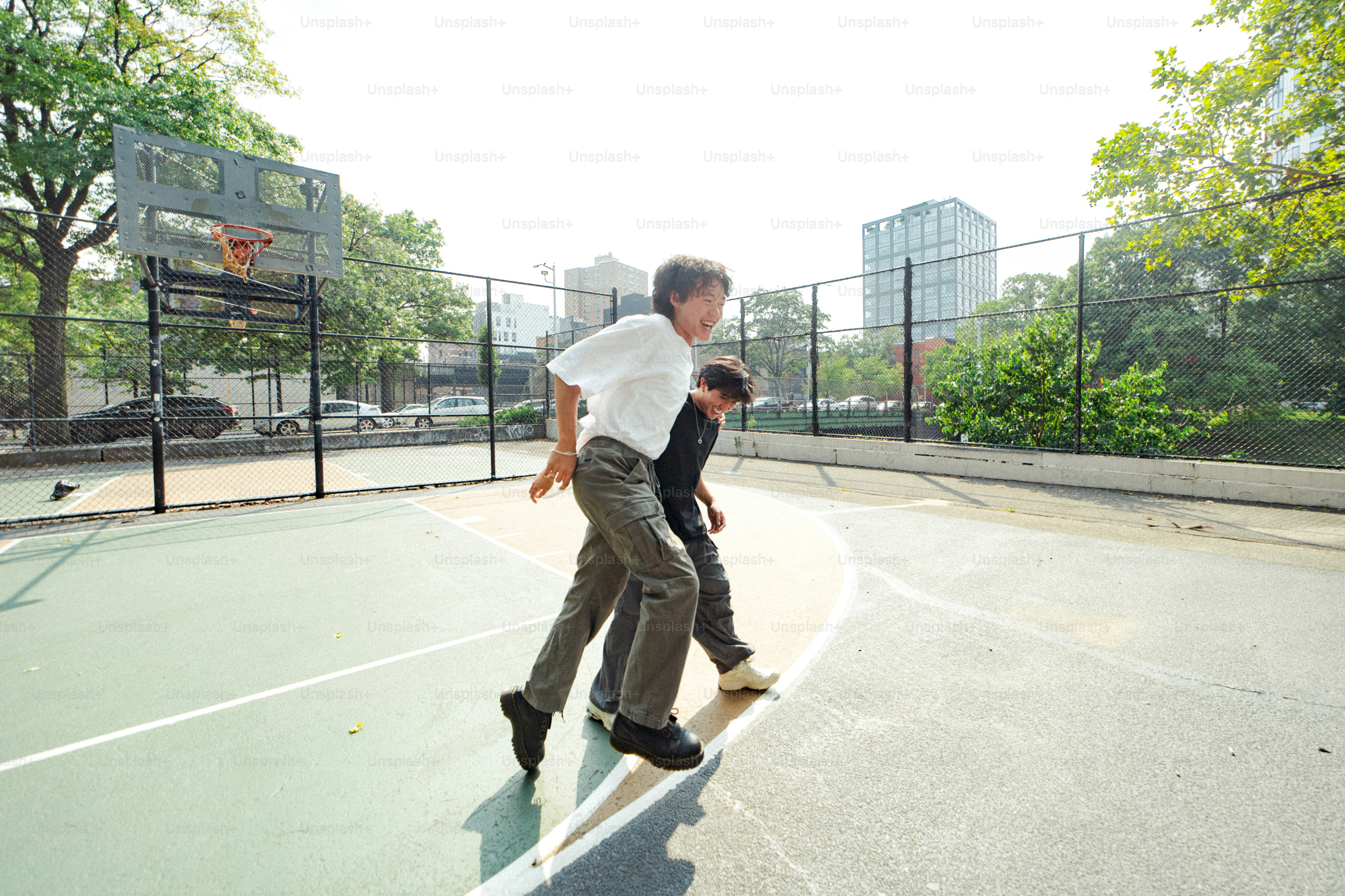 Ein Mann und ein Junge spielen Basketball auf einem Platz