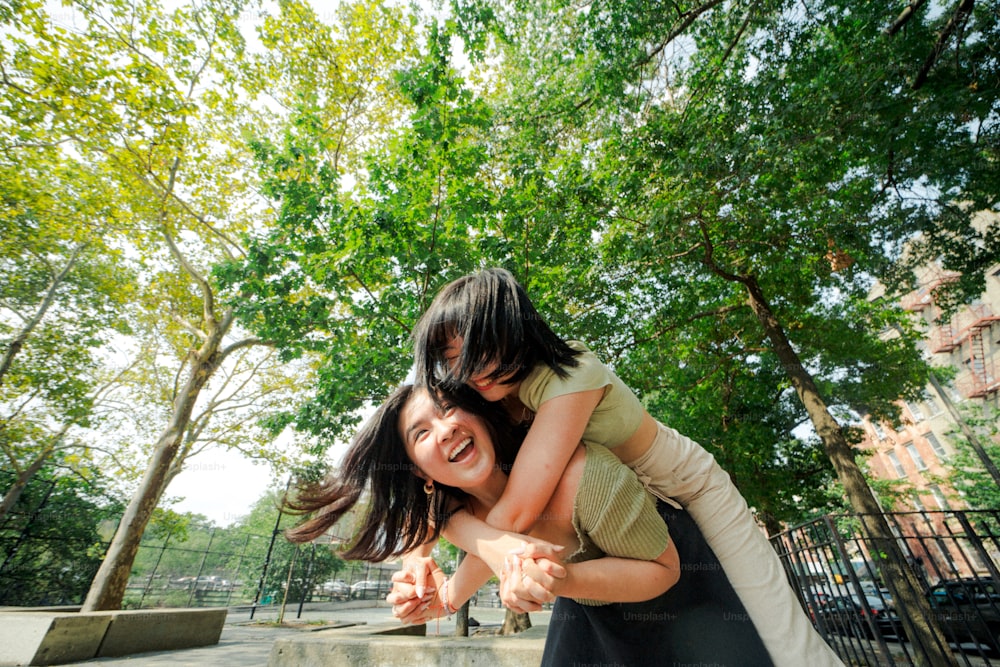 a woman holding a young girl in a park