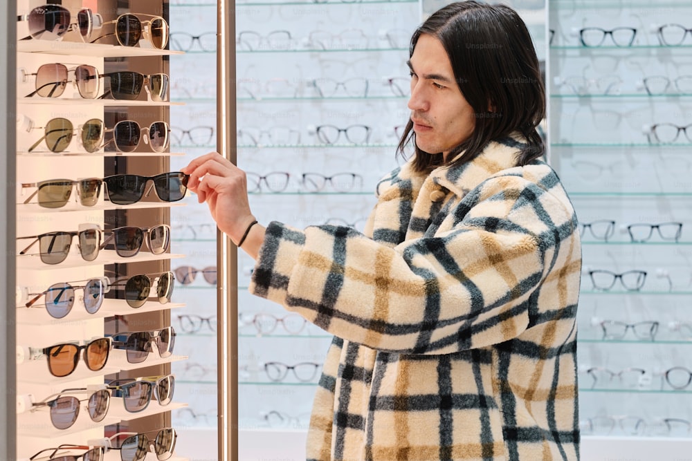 a man looking at a display of sunglasses