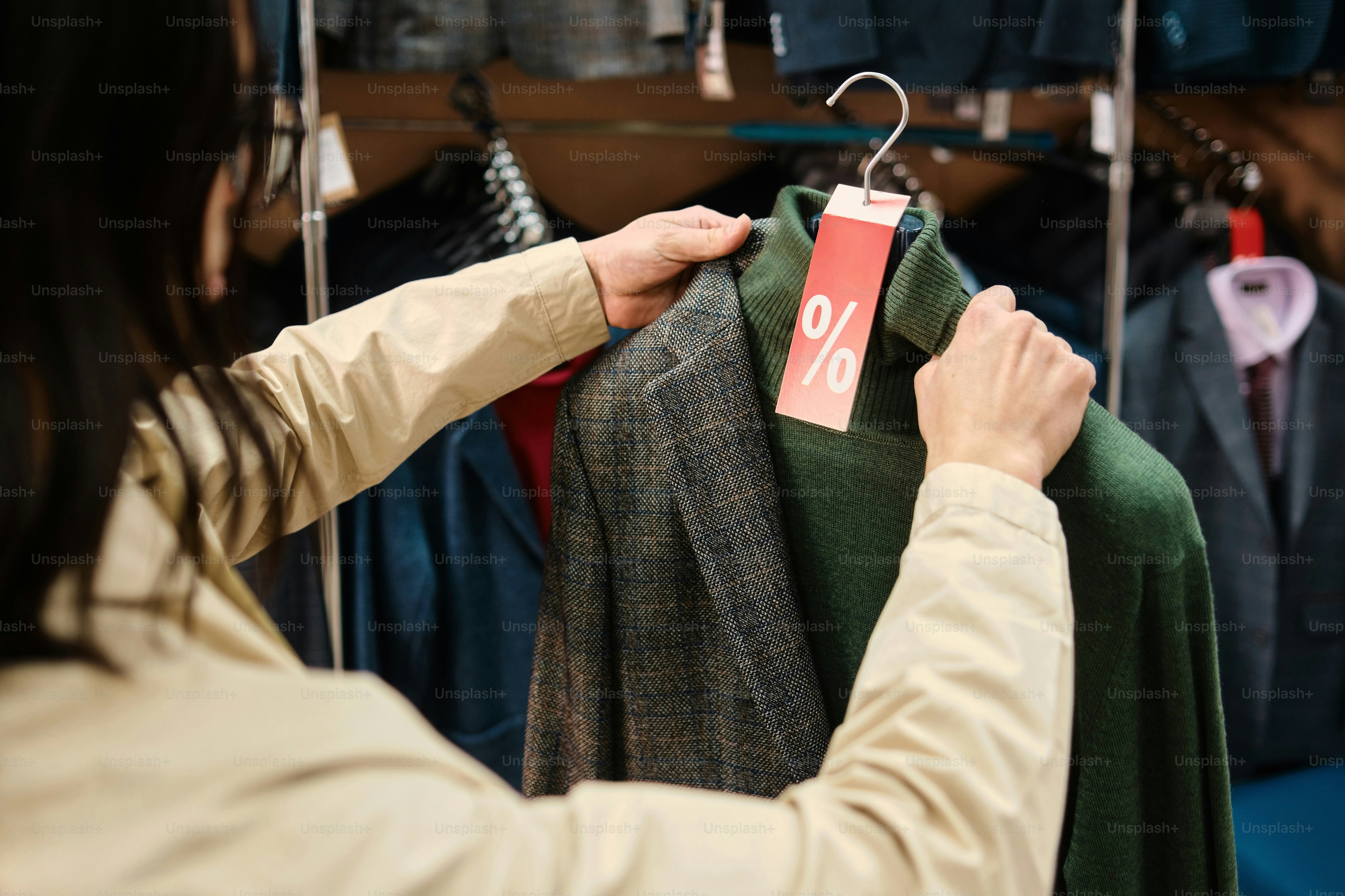 a woman is trying on a coat in a store