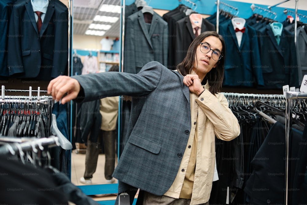 a woman standing in front of a rack of clothes