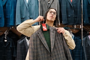 a man is trying on a jacket in a store
