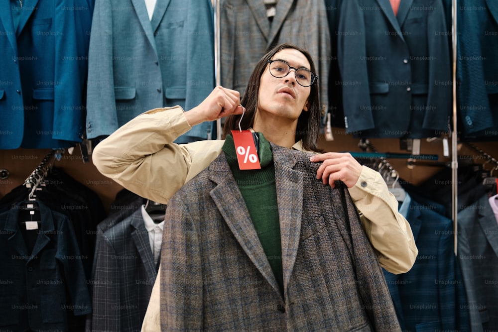 a man is trying on a jacket in a store