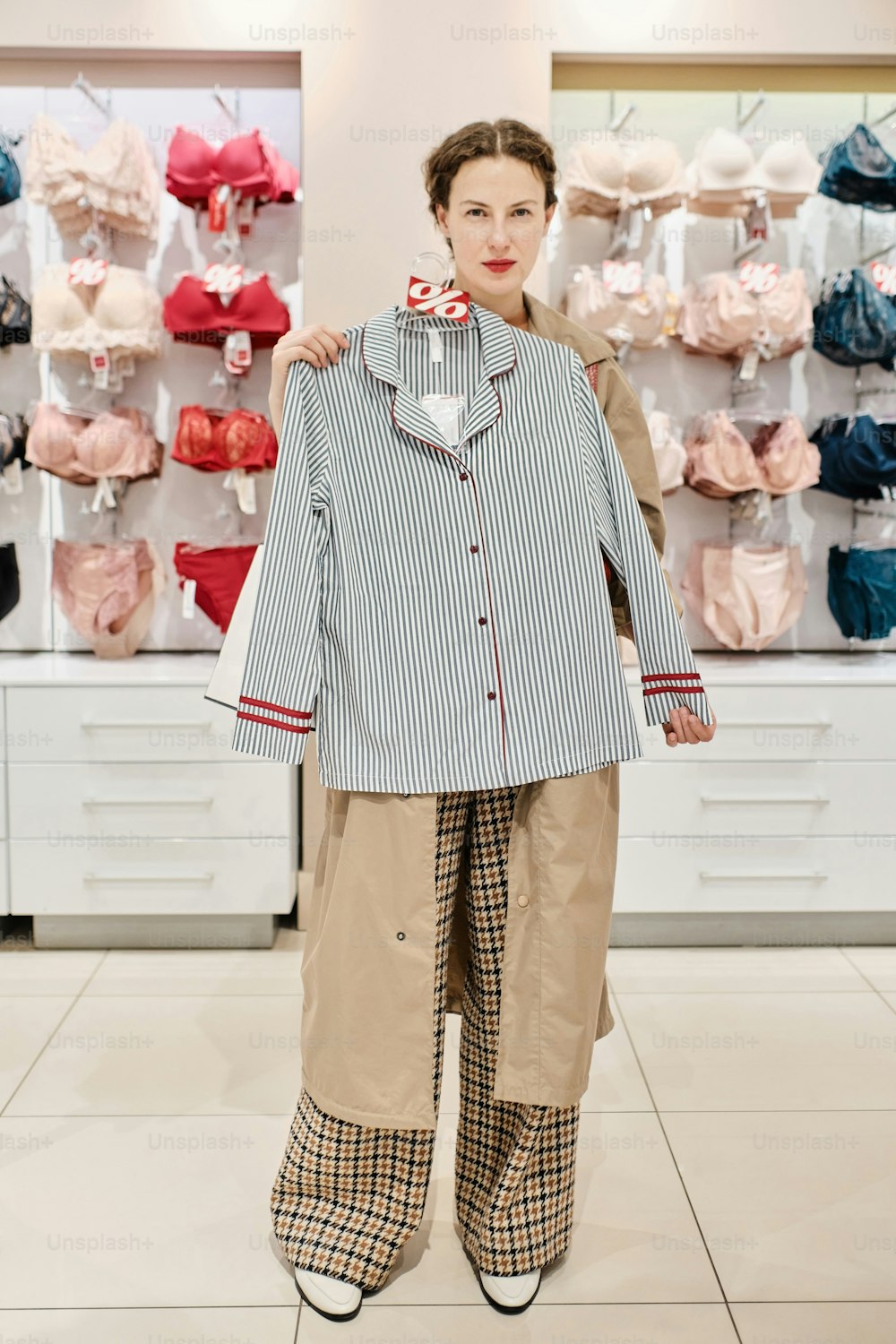 a woman standing in front of a display of clothing