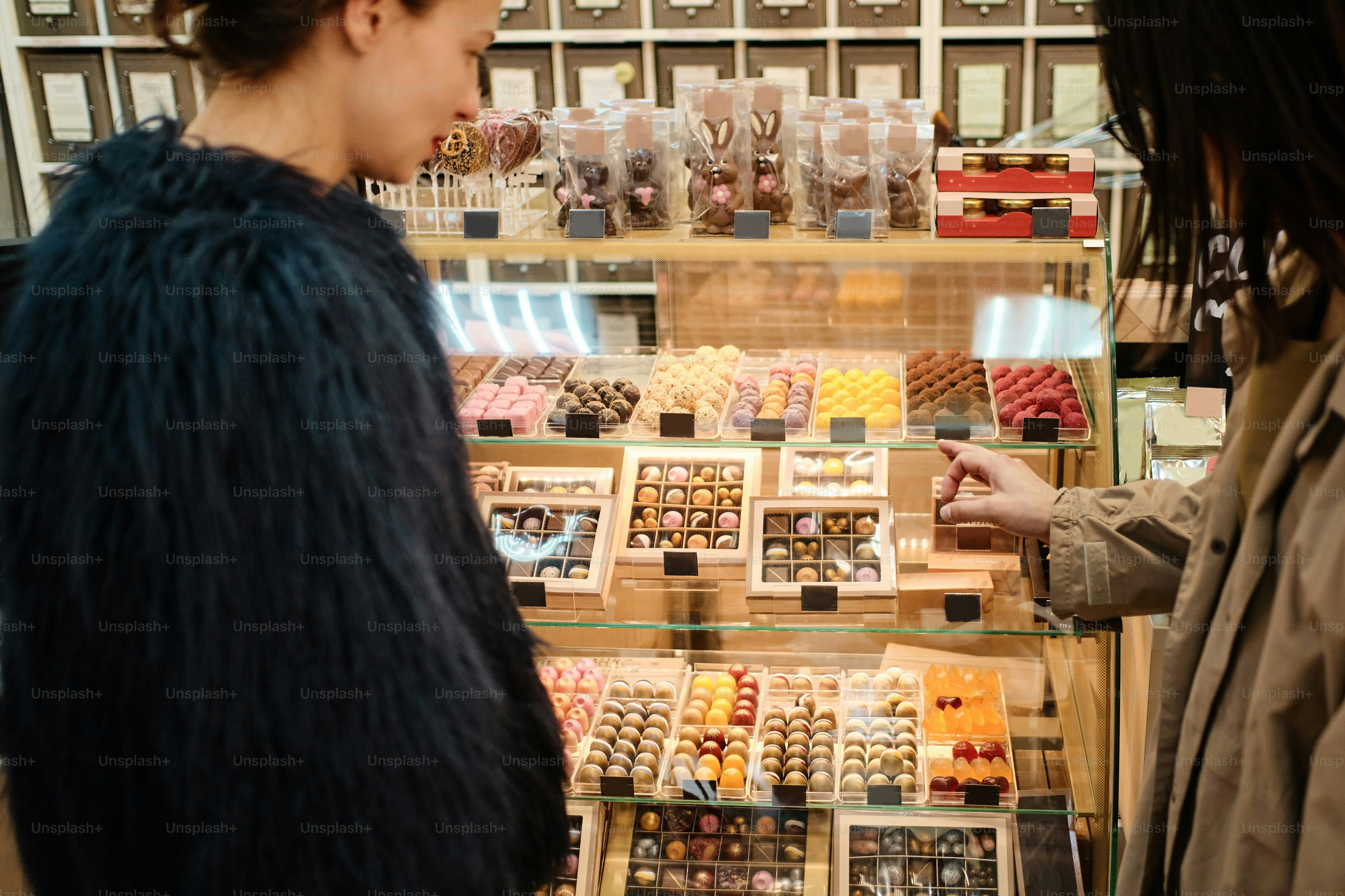un couple de femmes debout devant une vitrine