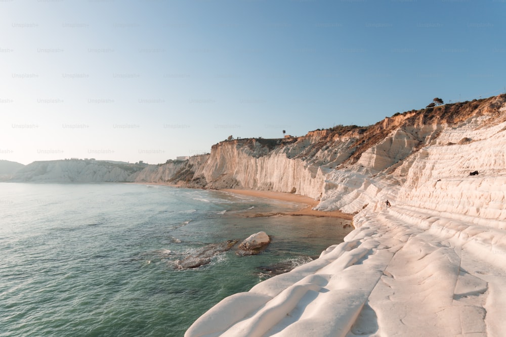a beach covered in snow next to a cliff