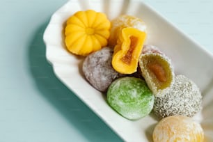 a white plate topped with different colored powdered donuts