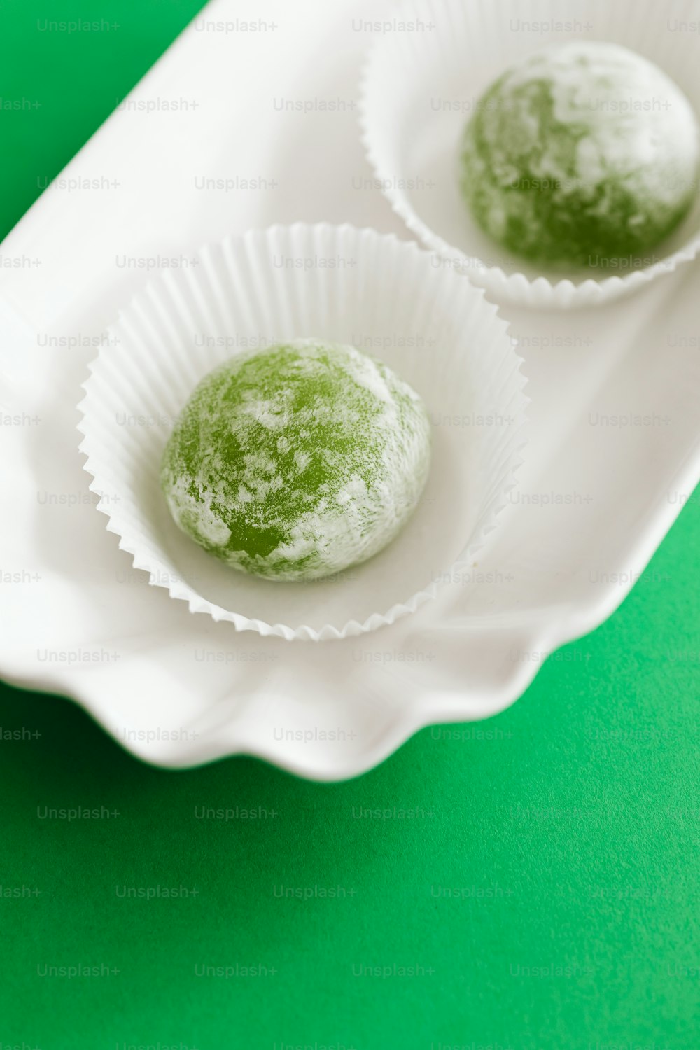 two powdered donuts sitting in a paper bowl