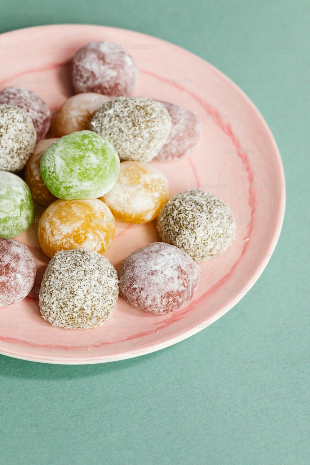 a plate of powdered donuts on a green table