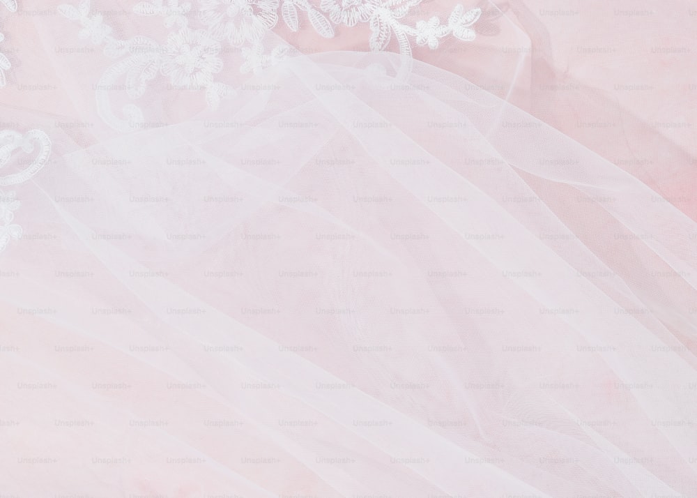 un primer plano de un vestido de novia sobre un fondo rosa