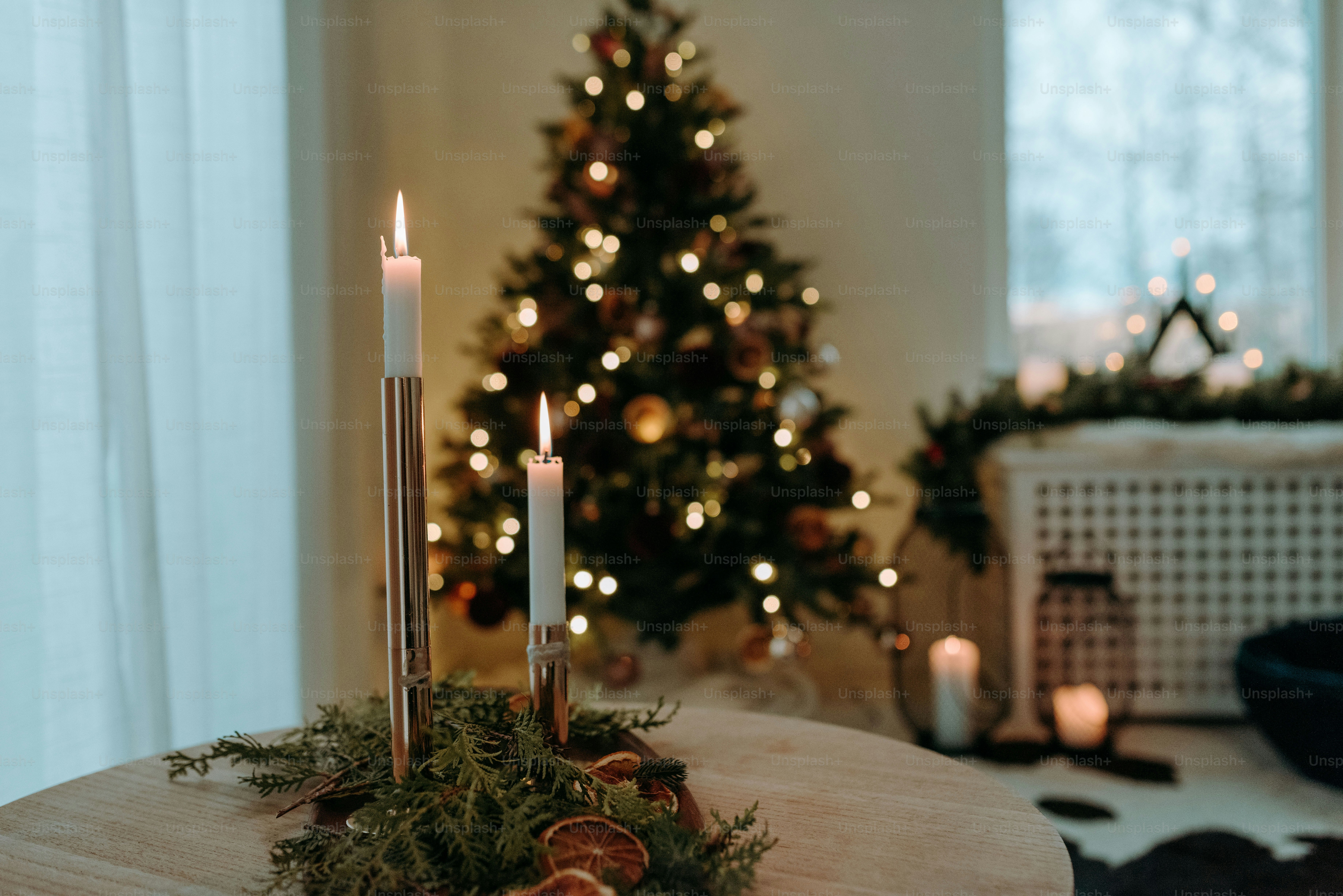 Uma mesa com velas e uma árvore de Natal ao fundo