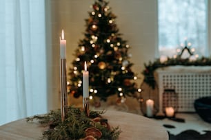 a table with candles and a christmas tree in the background