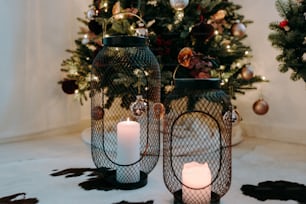 Um par de lanternas sentado ao lado de uma árvore de Natal