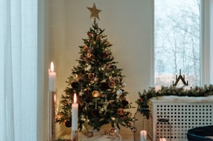Un albero di Natale decorato davanti a una finestra