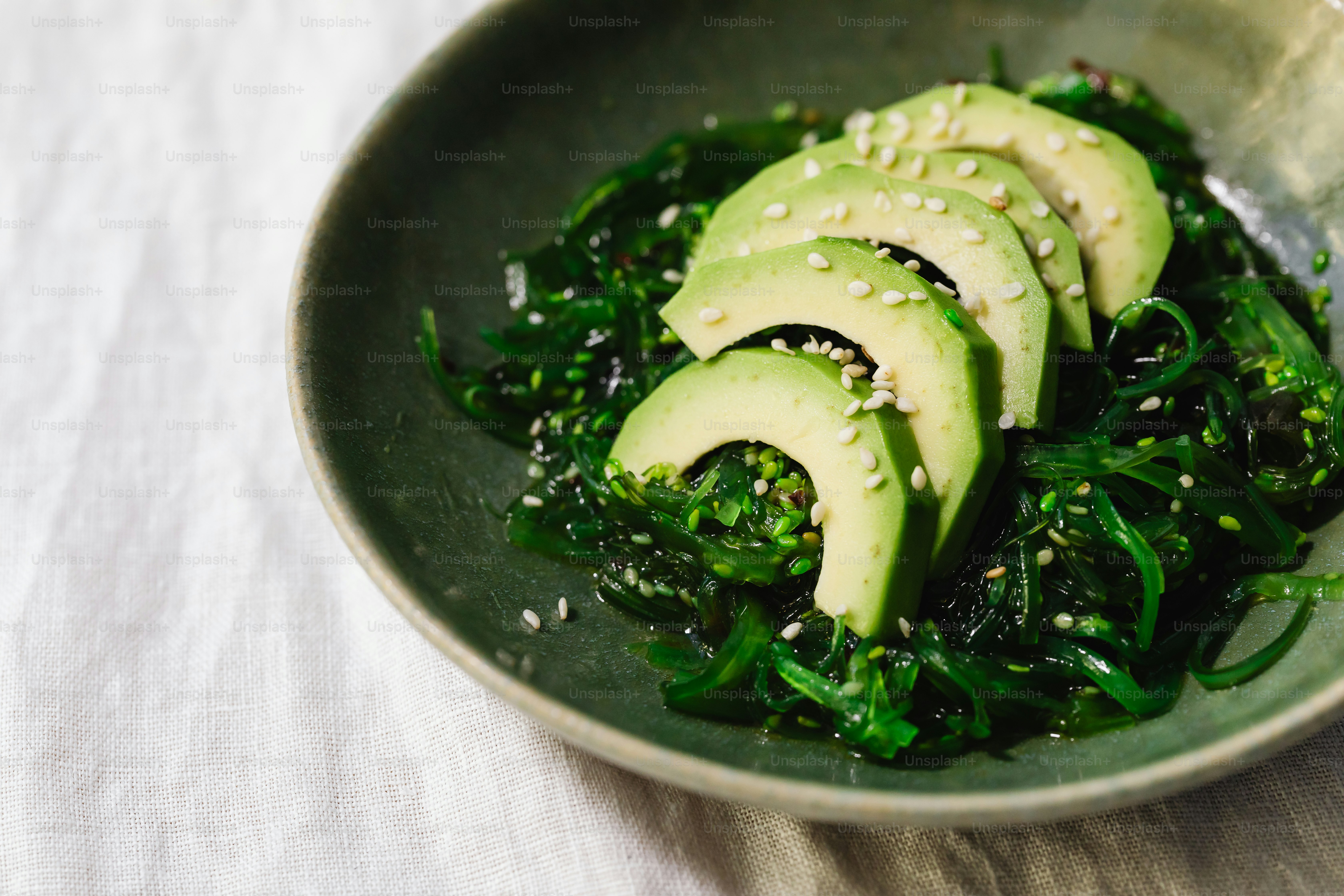 a bowl filled with sliced avocados and greens