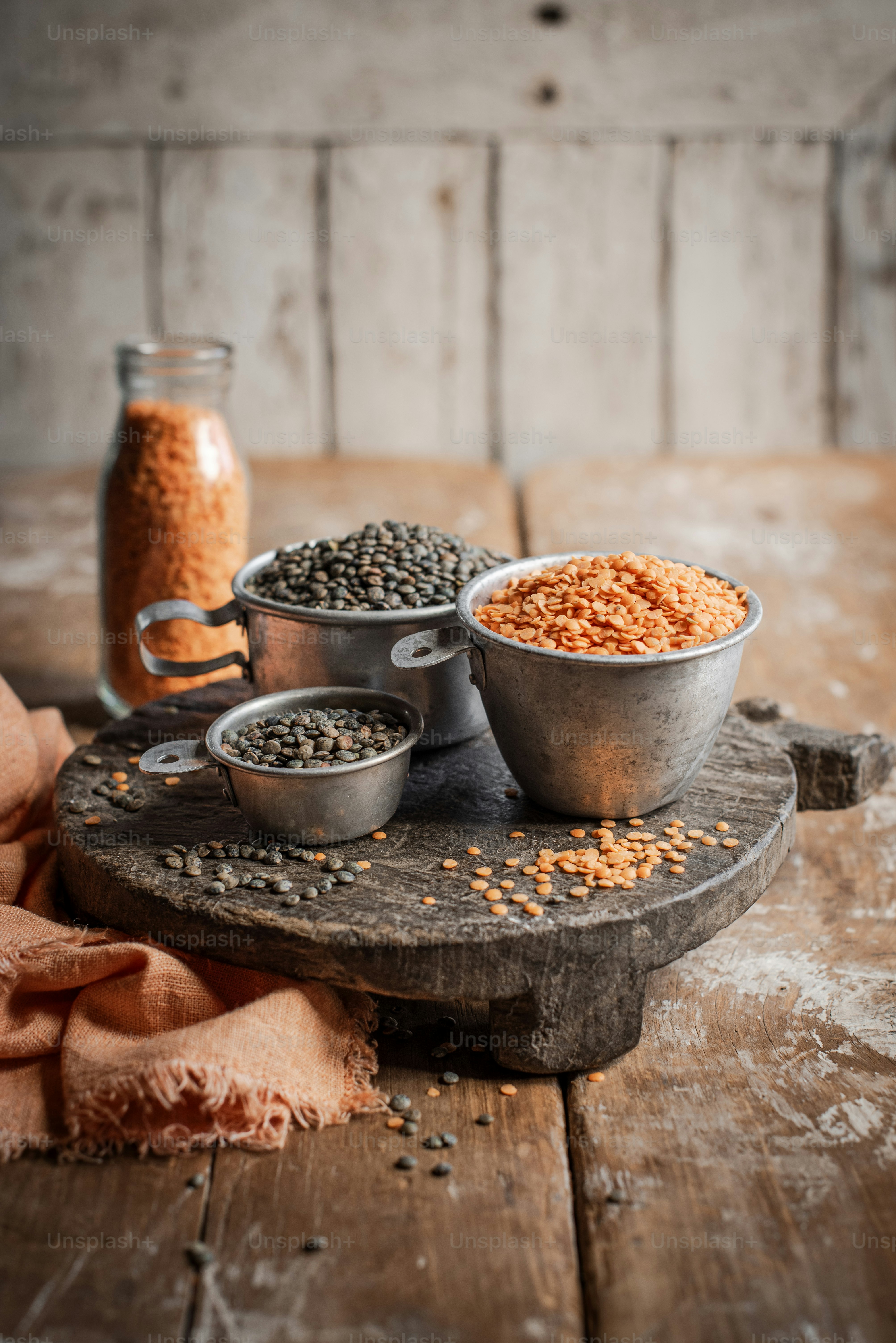 a wooden table topped with metal bowls filled with food