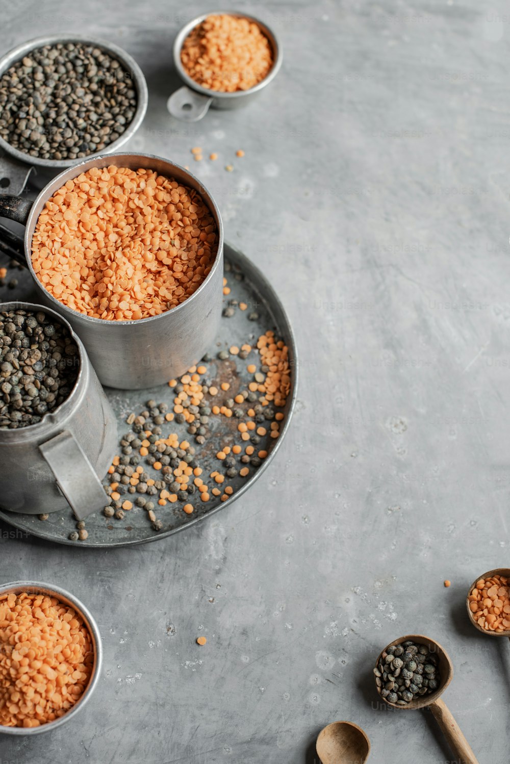 a metal tray topped with metal measuring cups filled with food