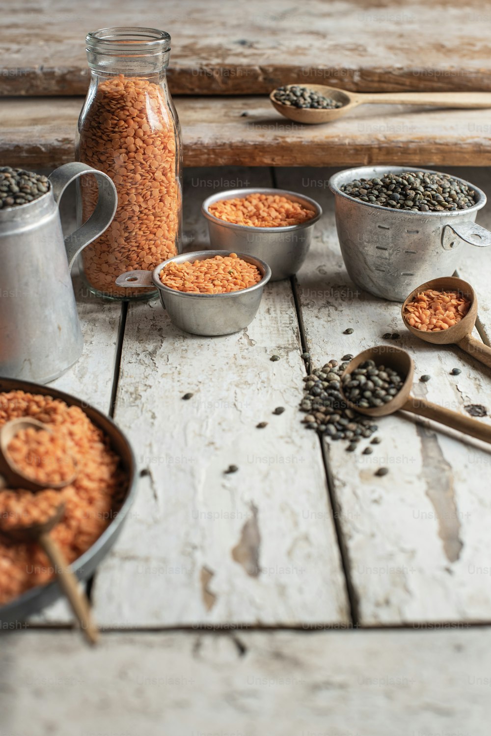 a wooden table topped with metal containers filled with food