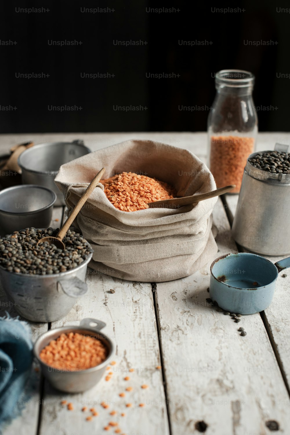 a wooden table topped with metal containers filled with food