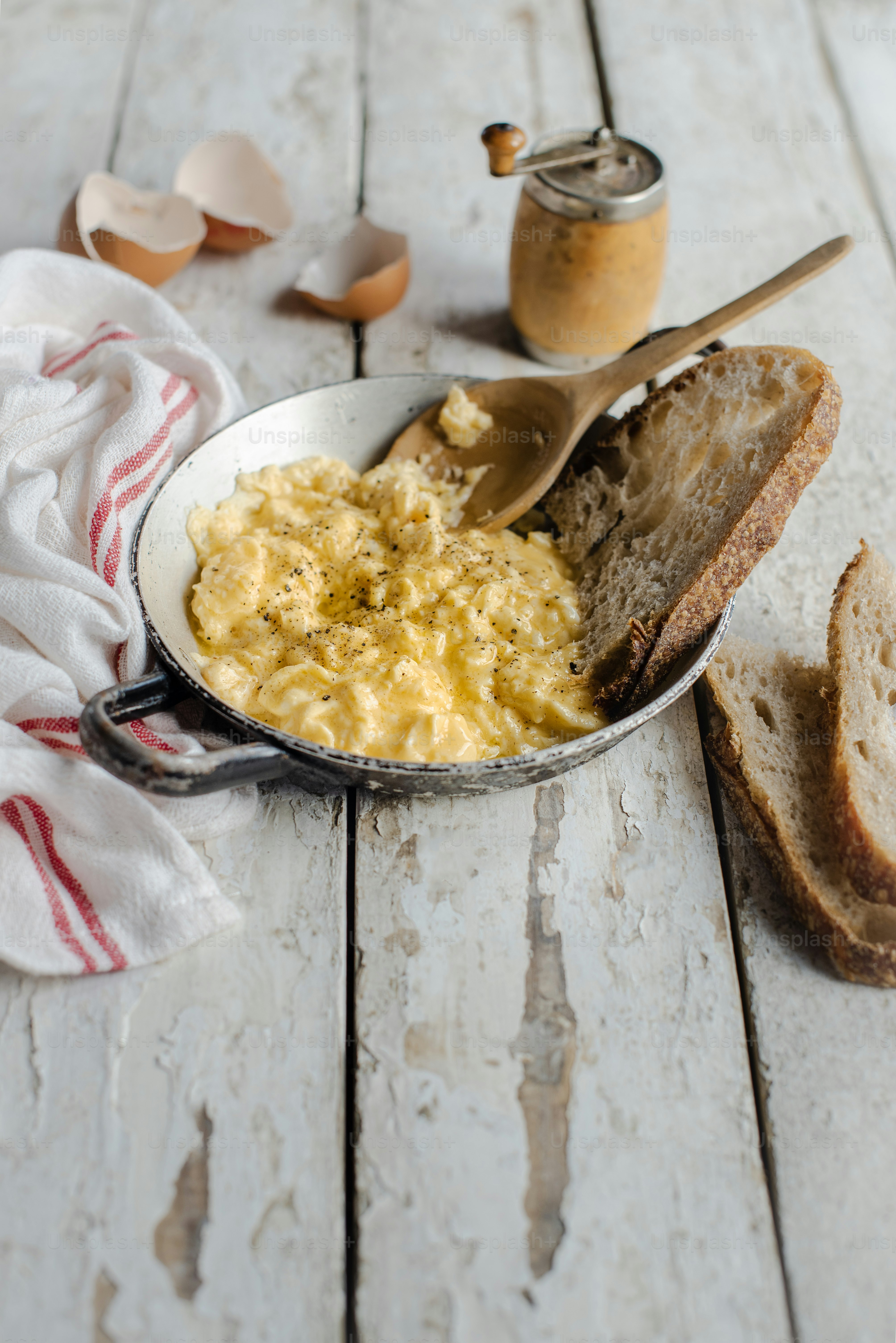 a bowl of scrambled eggs next to a slice of bread