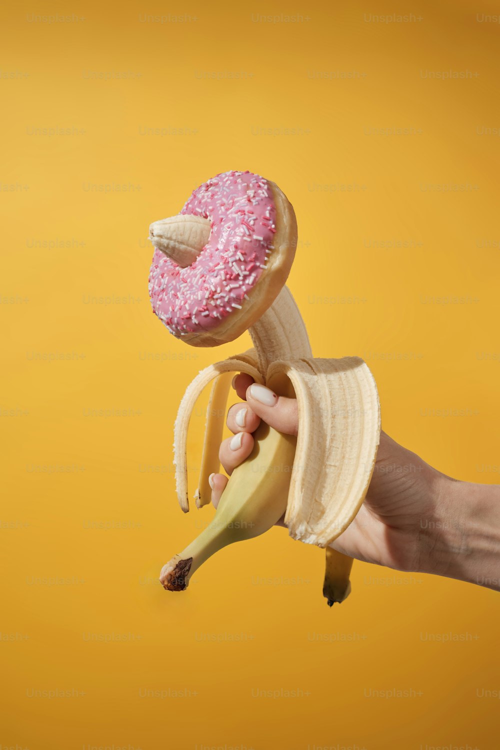 a person is holding a banana and a donut