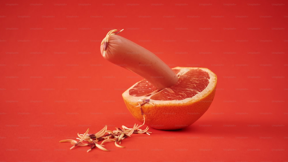 eine halbierte Grapefruit, aus der ein Messer herausragt