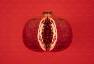 a pomegranate cut in half on a red background