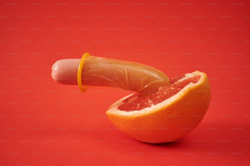 a hot dog on a stick sticking out of a grapefruit