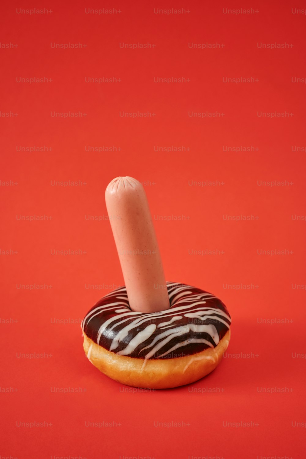 ein Donut, aus dem eine einzelne Kerze herausragt