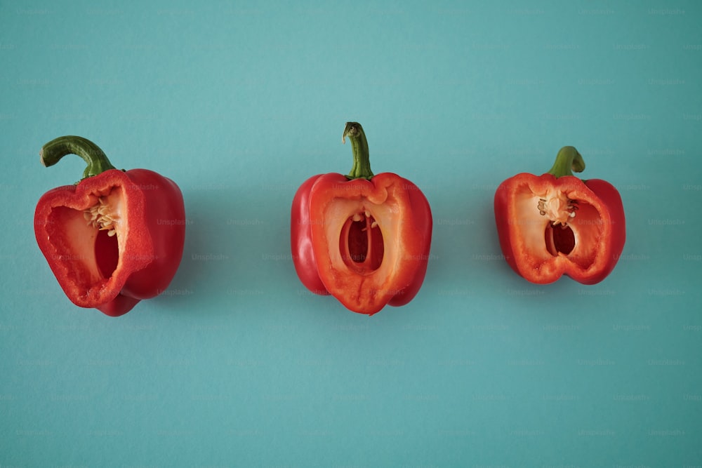 three red peppers on a blue background