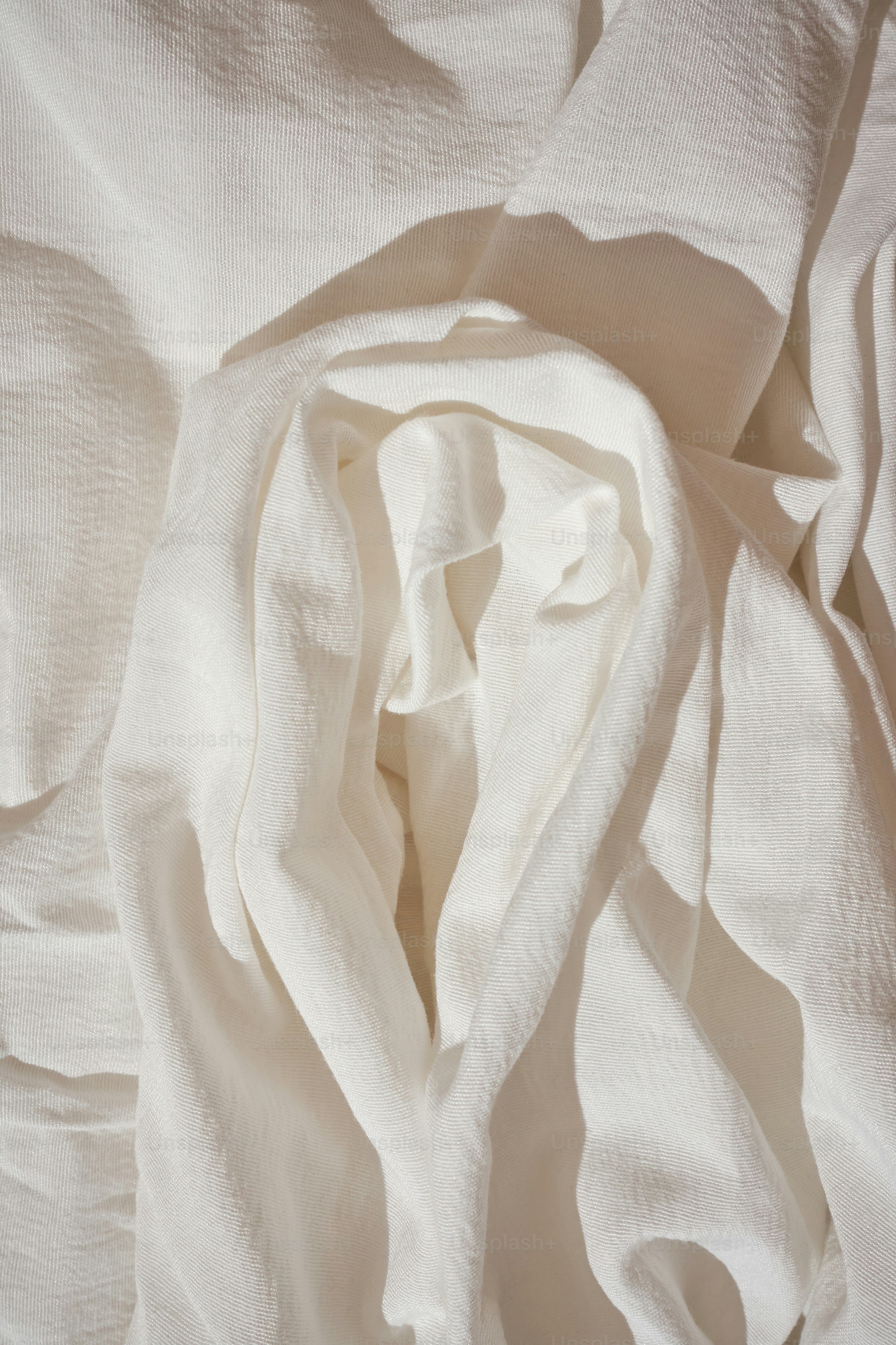 a close up of a white sheet on a bed