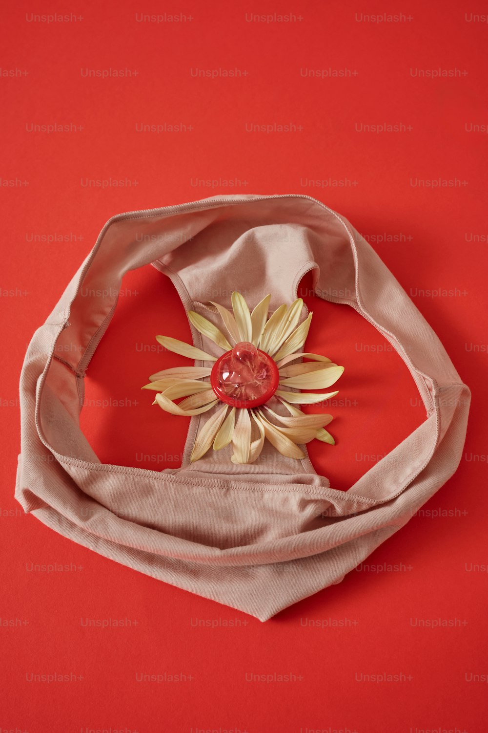 a white scarf with a flower on top of it