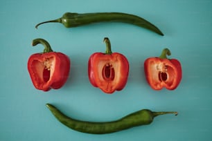 a group of red peppers with a green pepper in the middle